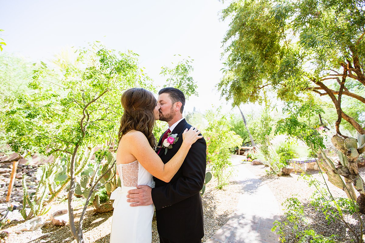 Classic bride and groom kiss in an Arizona desert garden by wedding photographer PMA Photography.
