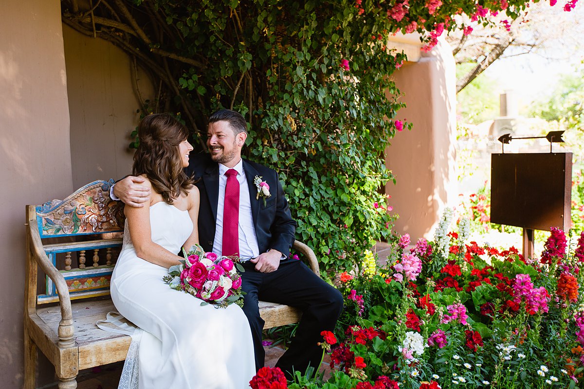 Bride and groom sitting in a garden at Hermosa Inn in Phoenix Arizona by wedding photographers PMA Photography.
