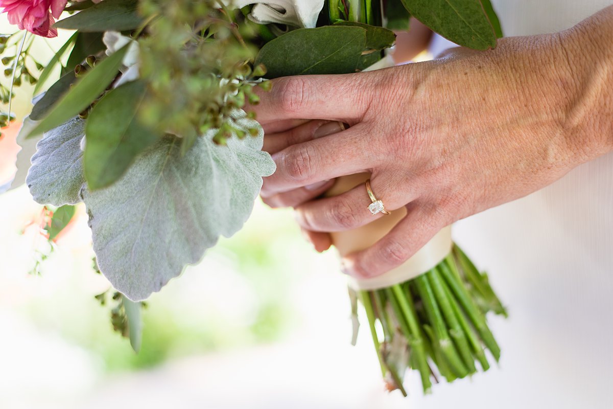 Bride's simple engagement ring holding her bouquet by PMA Photography.