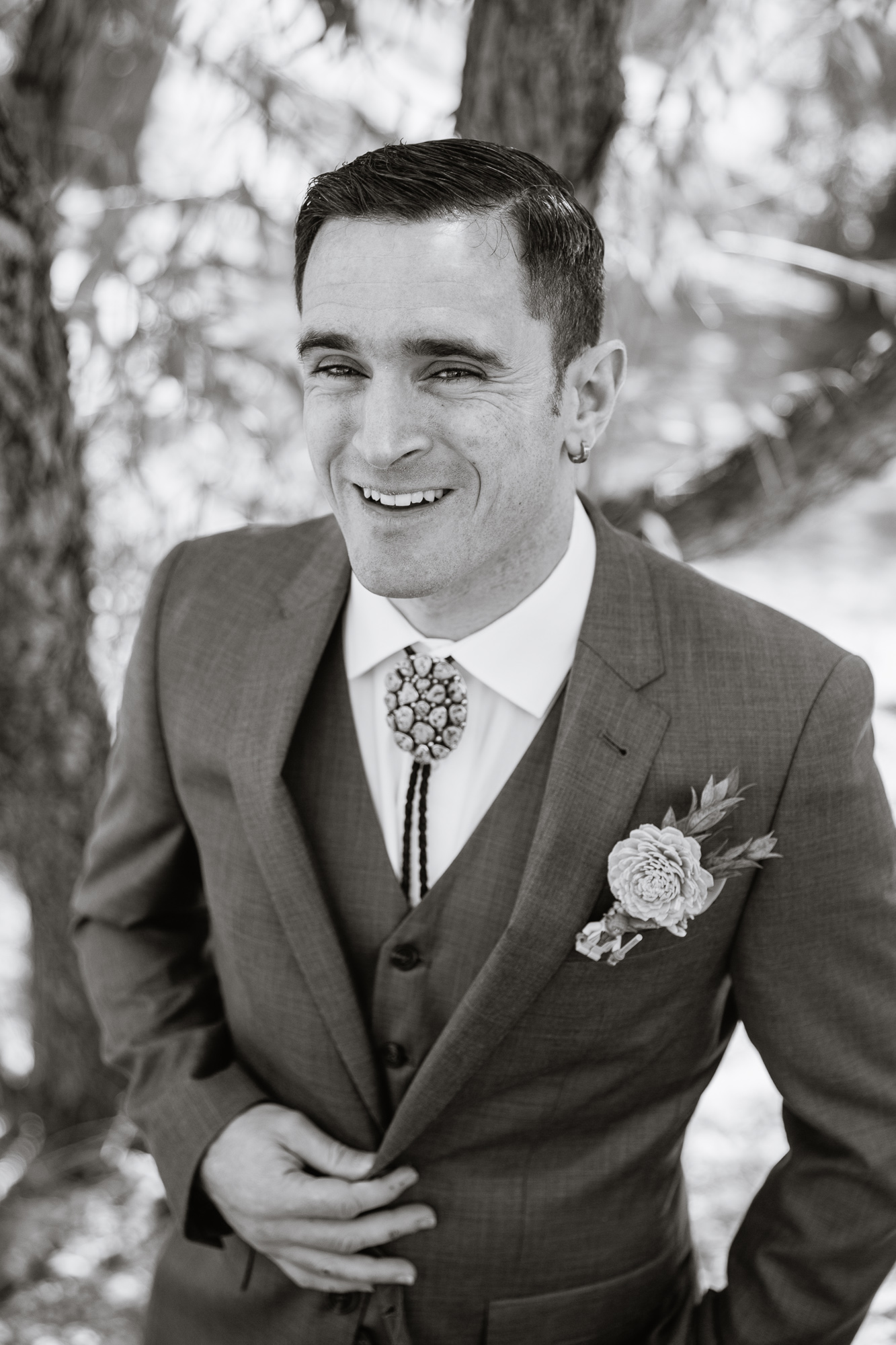 Black and white image of groom laughing by Arizona wedding photographer PMA Photography.