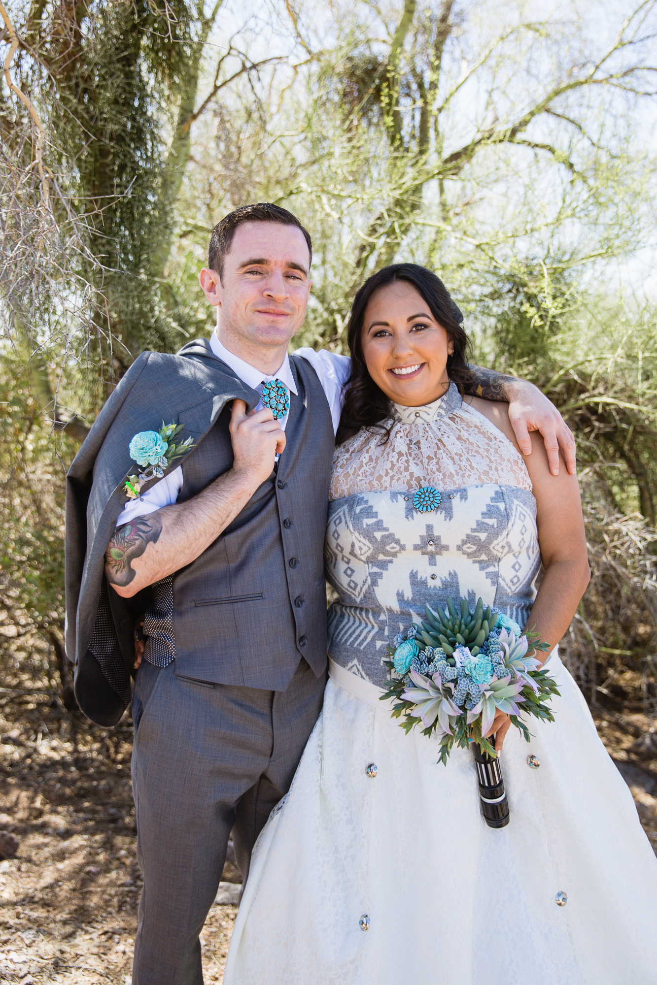 Tattooed and Irish groom and Navajo bride in a native inspired wedding dress at their Lost Dutchman State Park Star Wars wedding by Phoenix wedding photographers PMA Photography.
