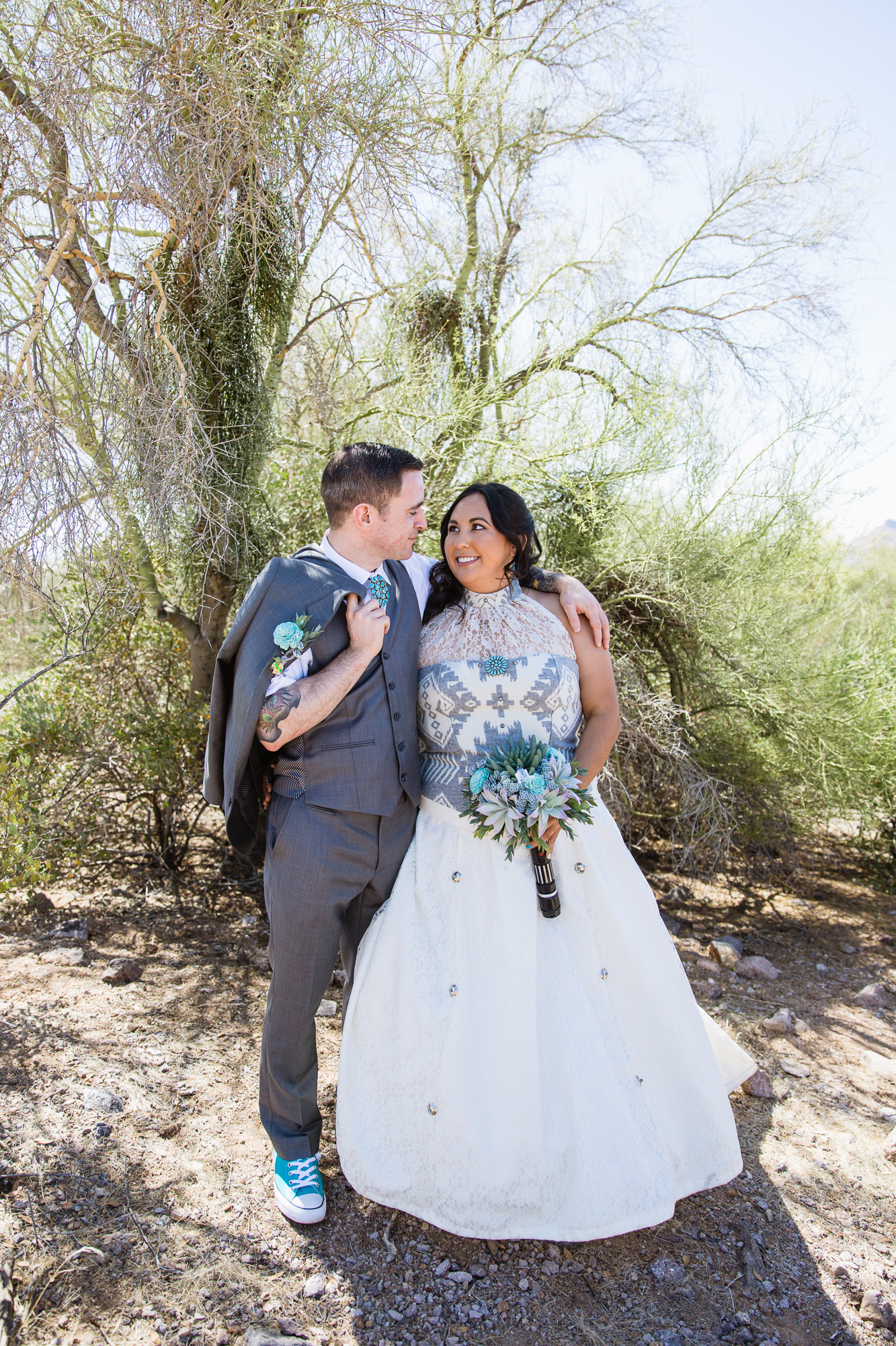 Tattooed and Irish groom and Navajo bride in a native inspired wedding dress at their Lost Dutchman State Park Turquoise Star Wars wedding by Phoenix wedding photographers PMA Photography.