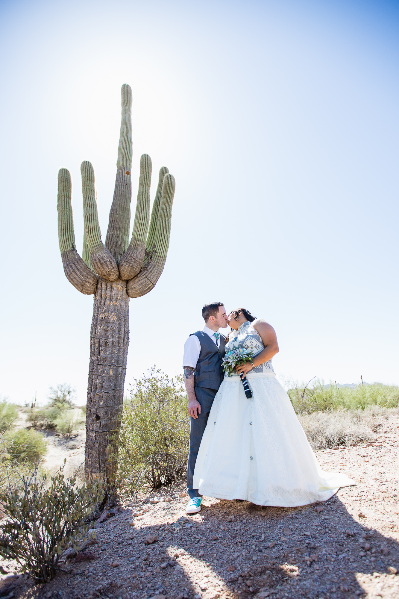 Tattooed Irish groom and Navajo bride in front of a Saguaro cactus at their Lost Dutchman State Park Turquoise Star Wars wedding by Phoenix wedding photographers PMA Photography.