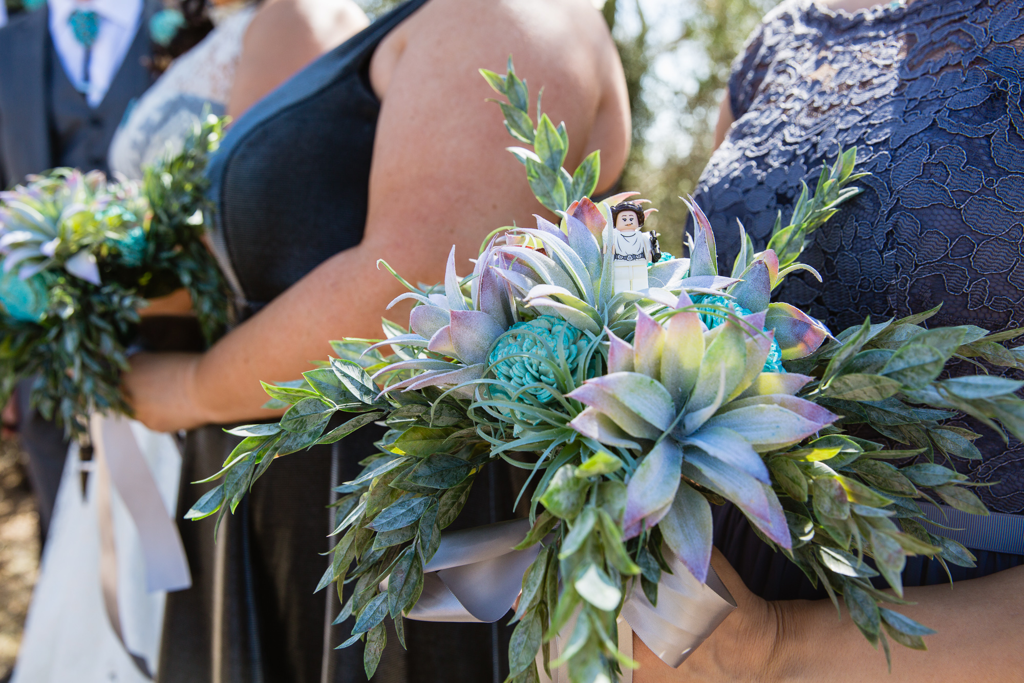 Star Wars Lego Princess Leia in a wood flower and succulent bridesmaids bouquet by Arizona wedding photographers PMA Photography.