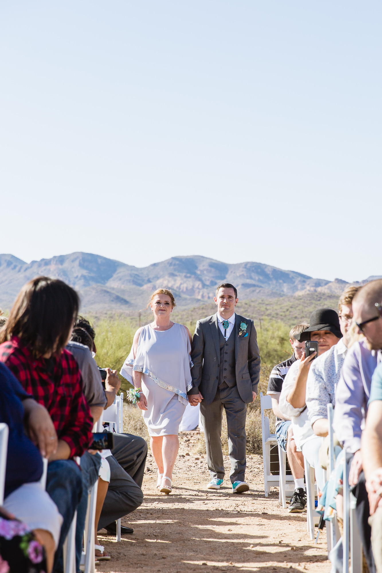 Groom walking down the aisle with his mother at Lost Dutchman State Park by Arizona photographers PMA Photography.