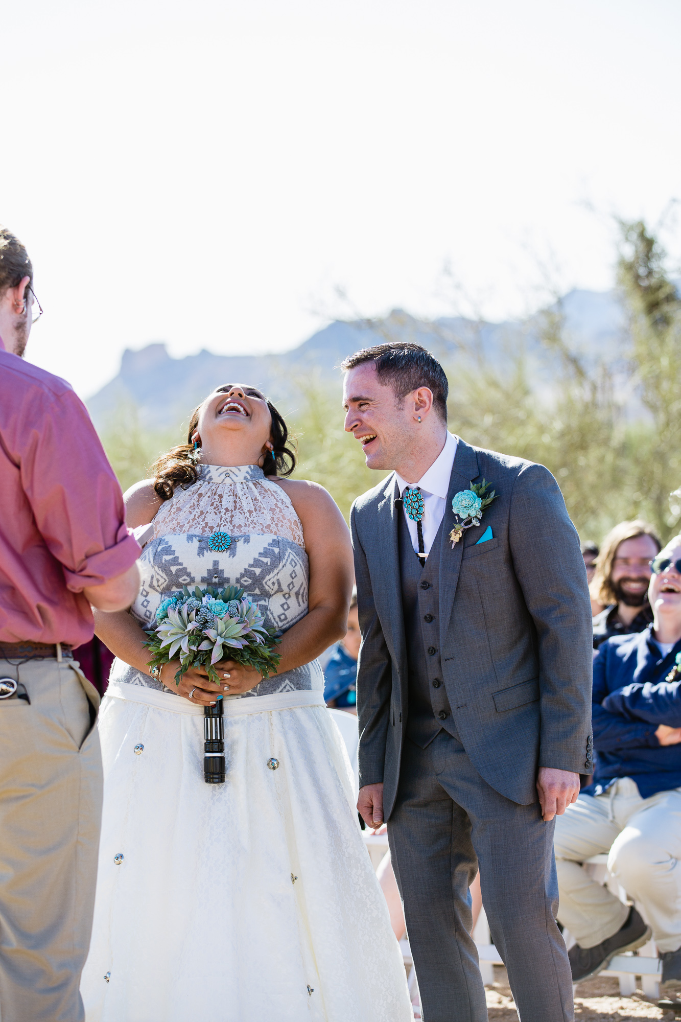 Bride and groom sharing a laugh during their Lost Dutchman State Park wedding ceremony by Arizona wedding photographer PMA Photography.