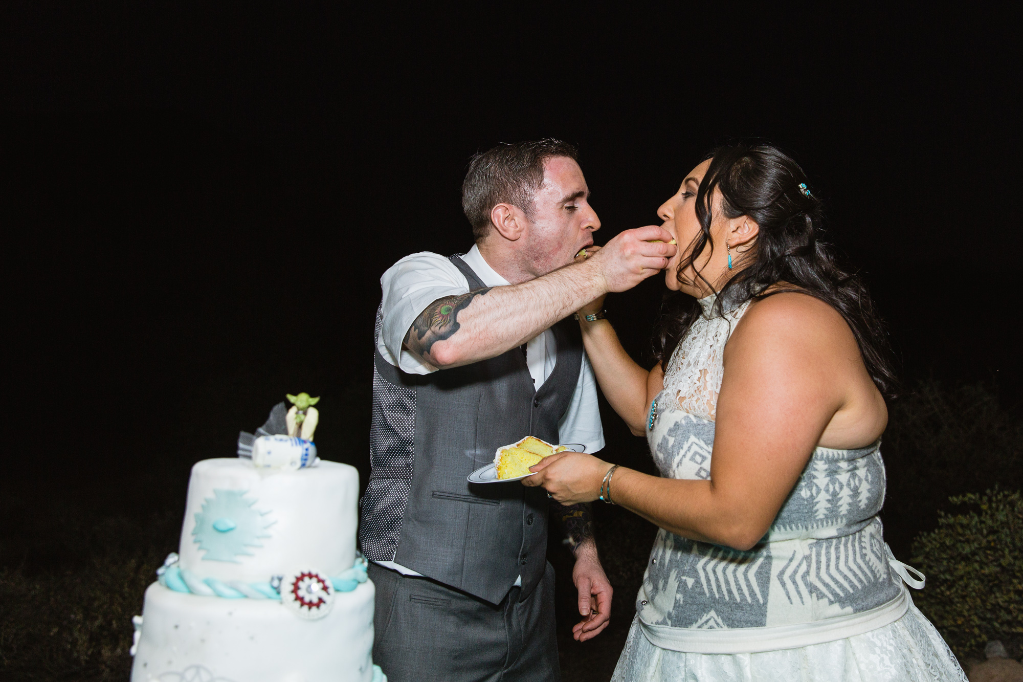 Bride and groom cutting the cake at their wedding reception by PMA Photography.