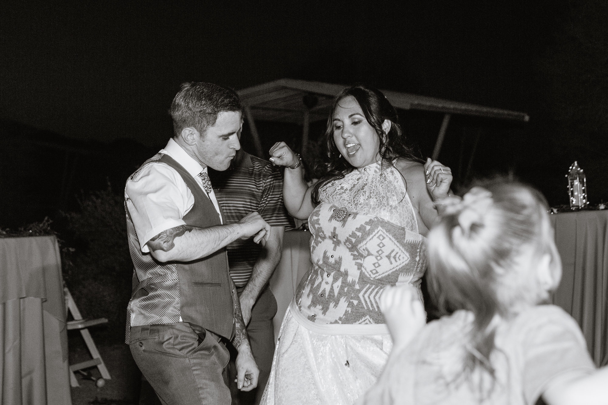 Bride and groom dancing with guests at their wedding reception by Arizona wedding photographer PMA Photography.