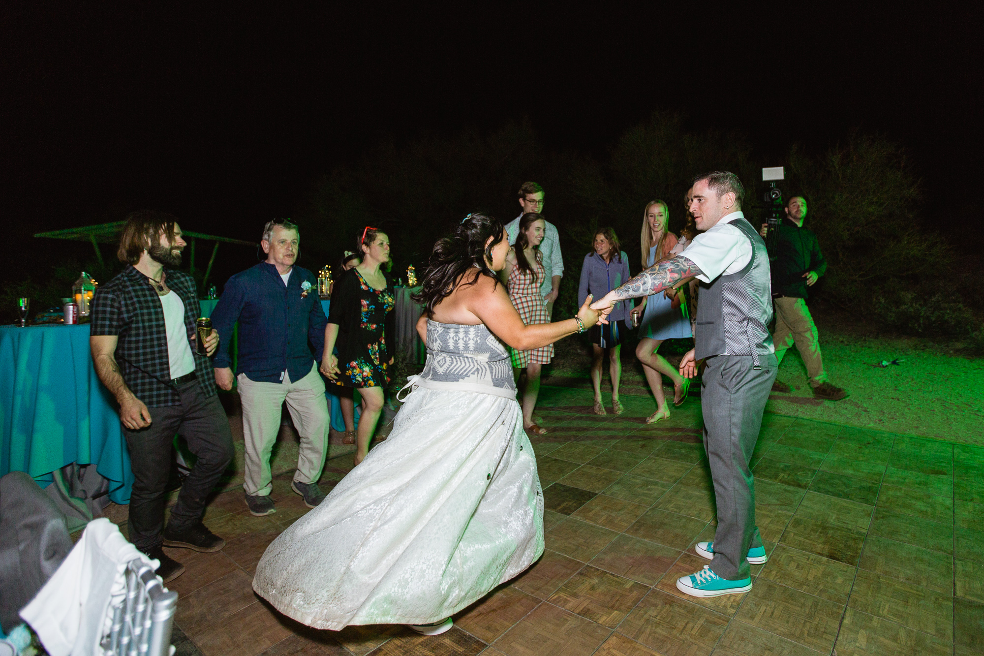 Bride and groom dancing with guests to an Irish song at their wedding reception by Arizona wedding photographer PMA Photography.