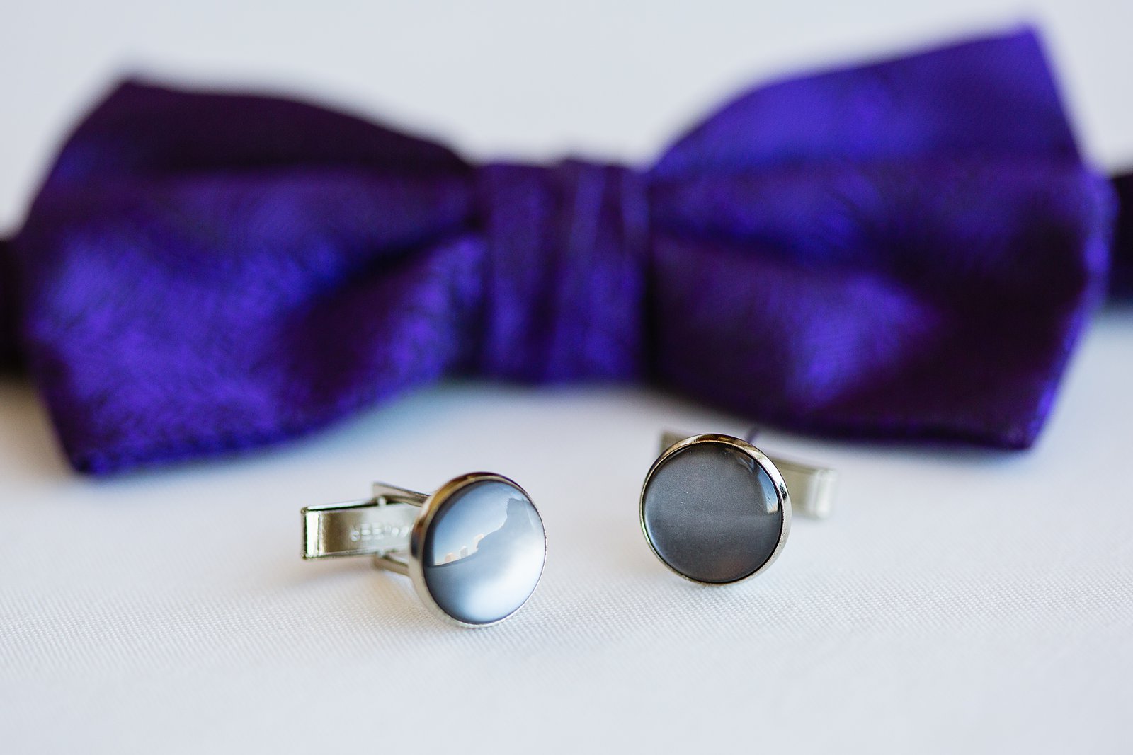 Groom's wedding day details of a purple bowtie and cufflinks by PMA Photography.
