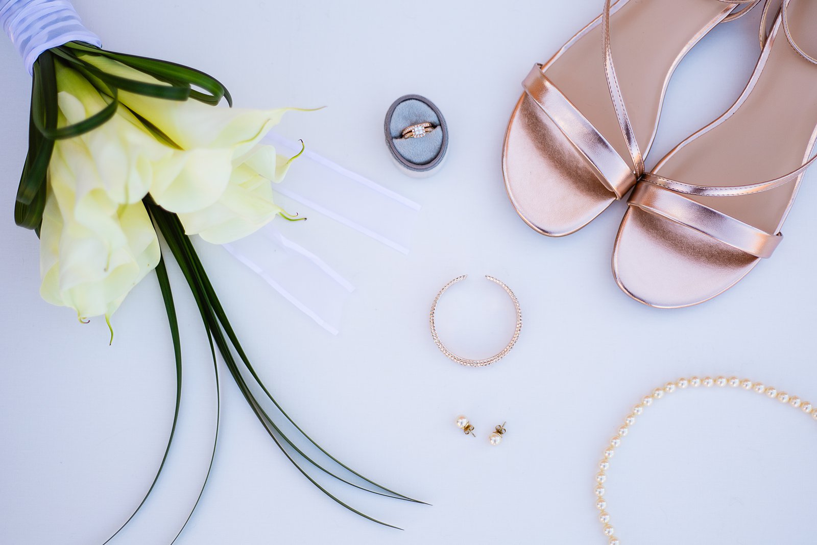 Brides's wedding day details of pearl and rose gold bridal jewelry and shoes by PMA Photography.