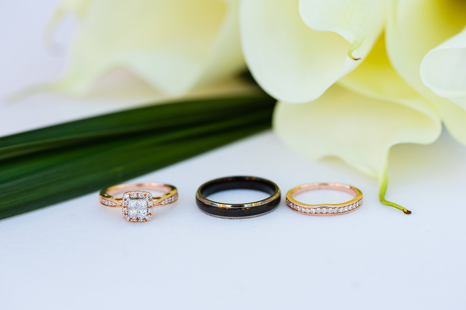 Bride and groom's black and rose gold wedding rings by PMA Photography.