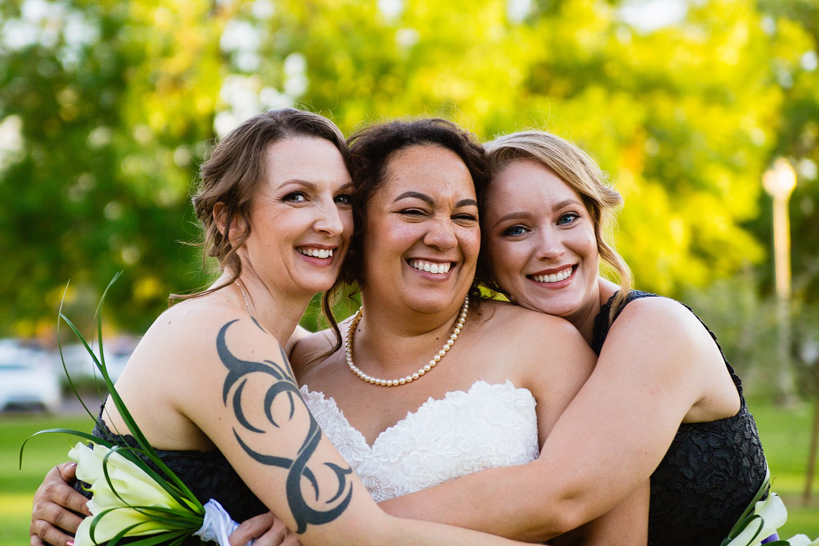 Bride and bridesmaids laughing together at Encanto Park wedding by Phoenix wedding photographer PMA Photography.