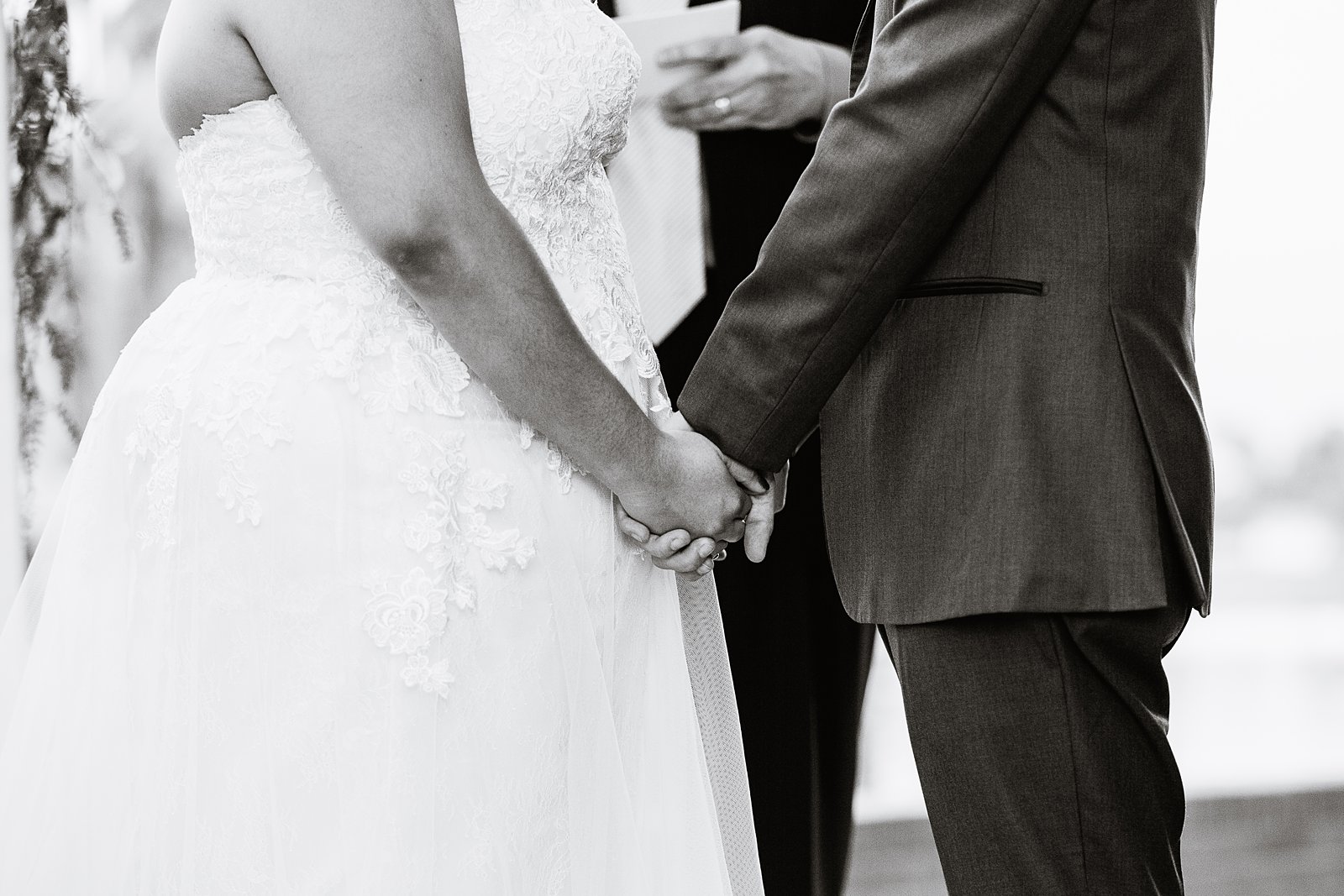 Bride and groom holding hand during their wedding ceremony by Phoenix wedding photographer PMA Photography.
