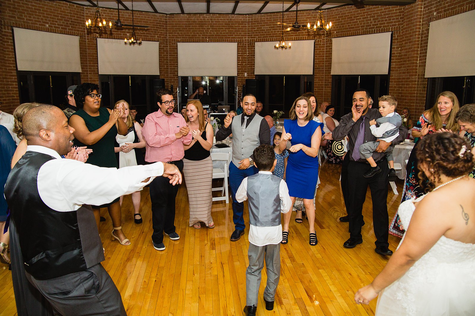Bride and groom dancing with guests at their Encanto Park wedding reception by Arizona wedding photographer PMA Photography