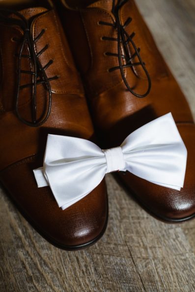 Groom's wedding day details of a white bow tie and tan leather shoes by PMA Photography.