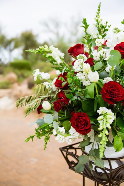 Red and white wedding ceremony floral arrangement at Troon North by Arizona wedding photographer PMA Photography.