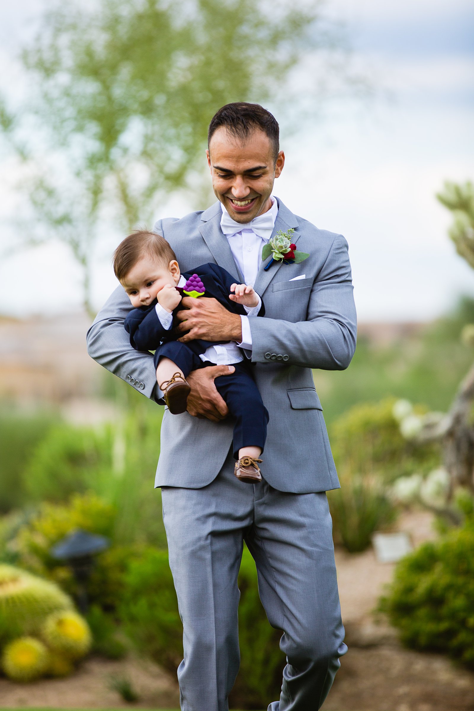 Groom and son walking down aisle during Troon North wedding ceremony by Arizona wedding photographer PMA Photography.