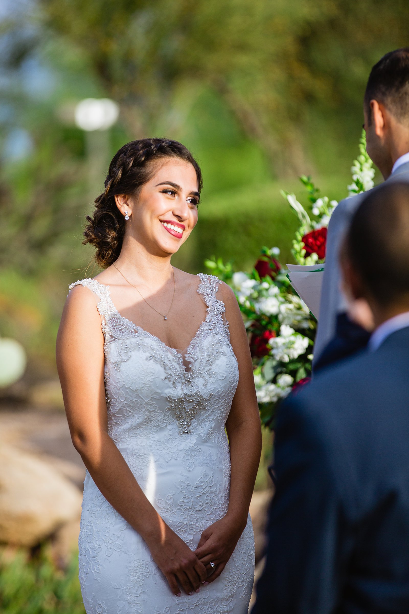 Bride looking at her groom during their wedding ceremony at Troon North by Scottsdale wedding photographer PMA Photography.
