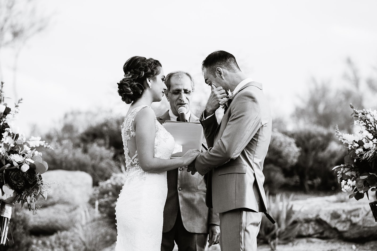 Groom wiping away a tear during the ring exchange wedding ceremony by Arizona wedding photographer PMA Photography.