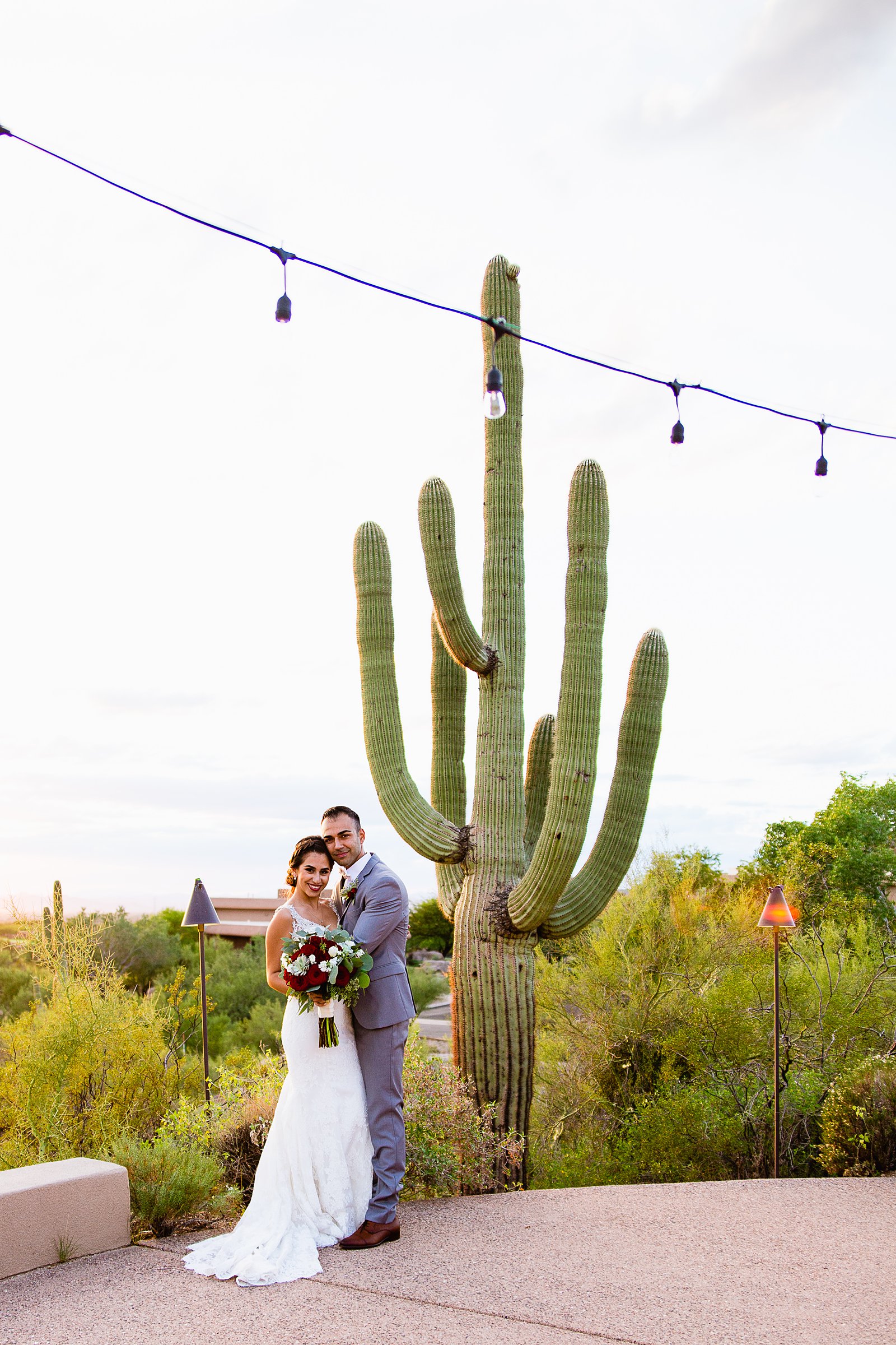Bride and groom pose for their Troon North wedding by Scottsdale wedding photographer PMA Photography.