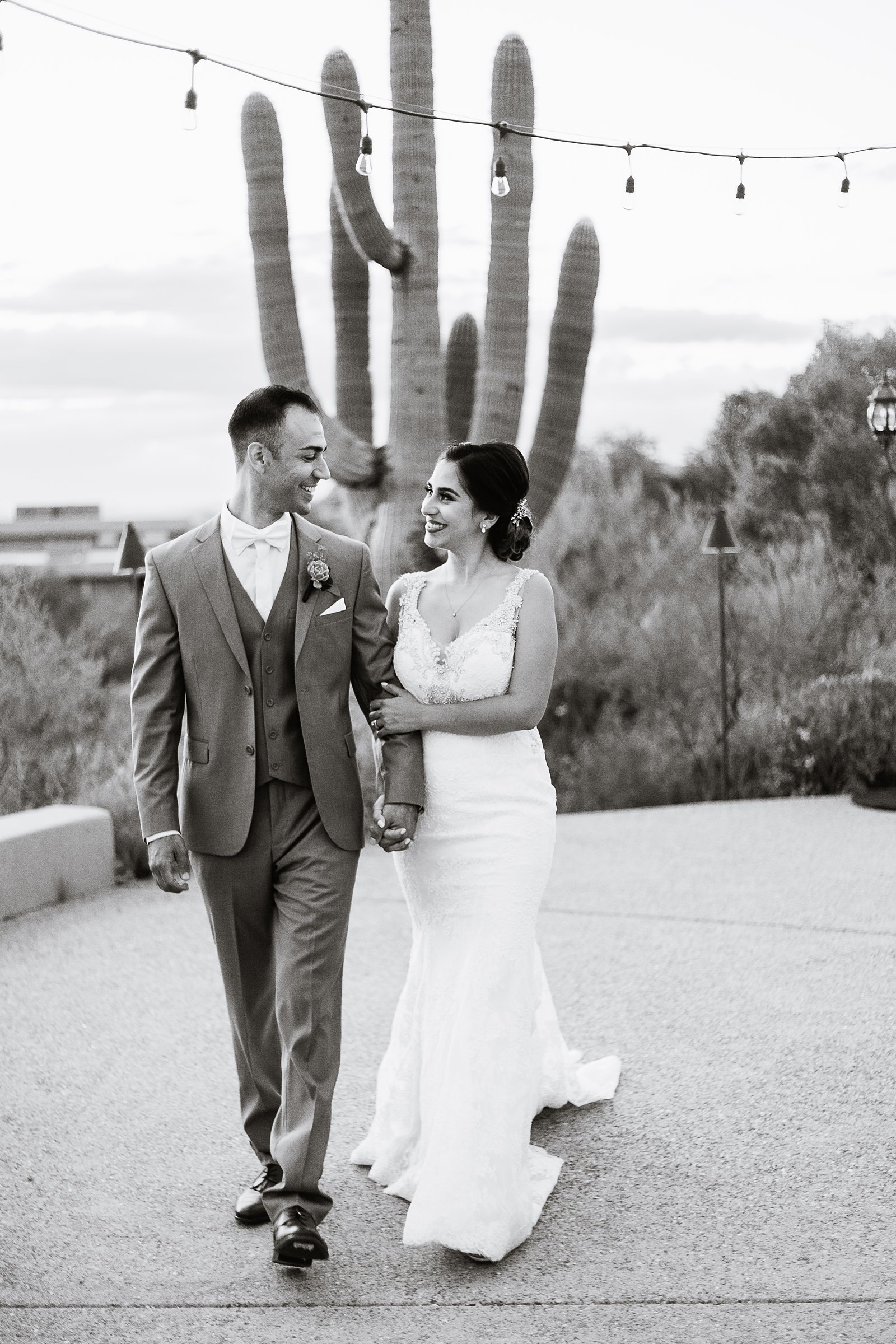 Bride and groom walking together during their Troon North wedding by Arizona wedding photographer PMA Photography.