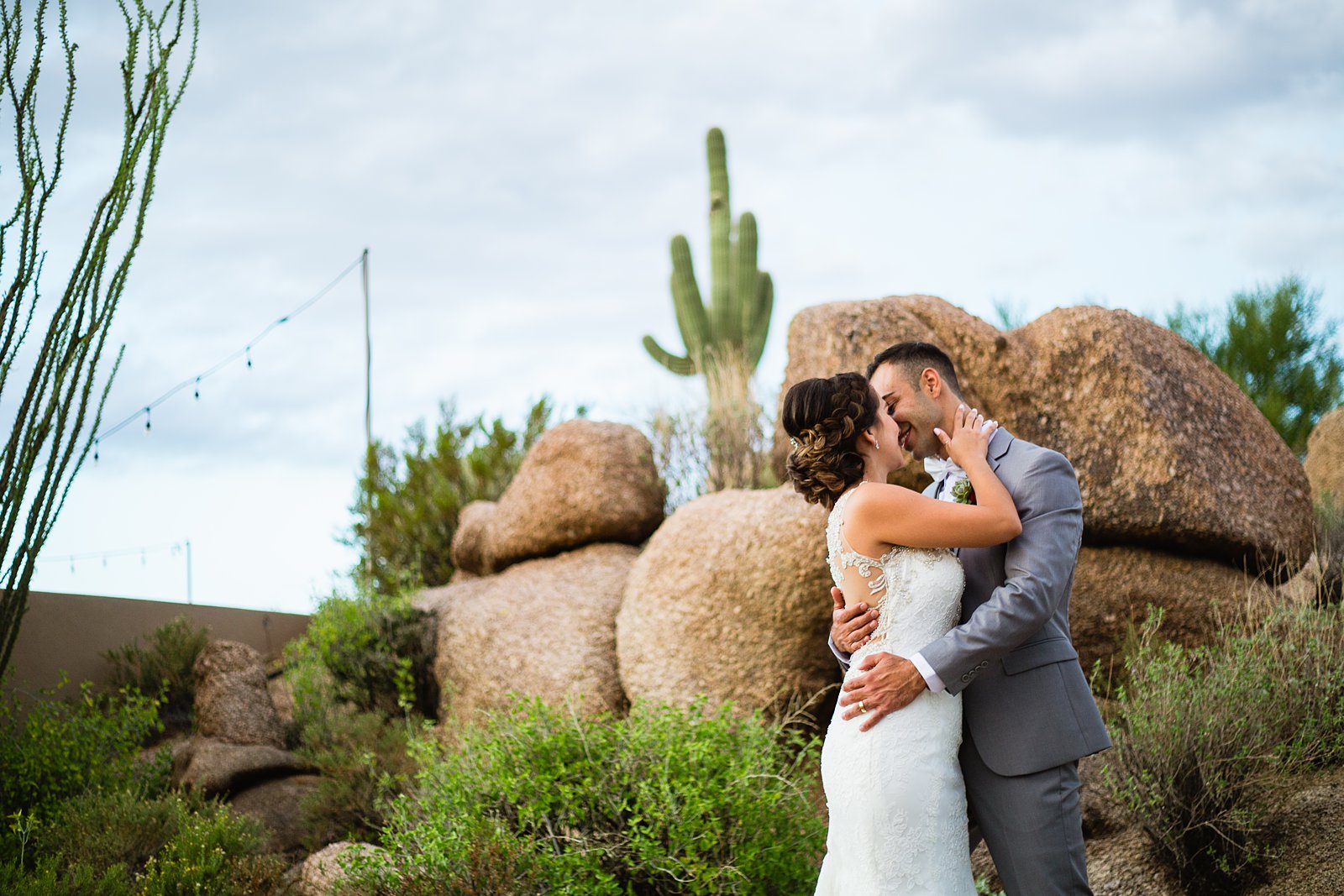 Bride and groom share a kiss during their Troon North wedding by Arizona wedding photographer PMA Photography.