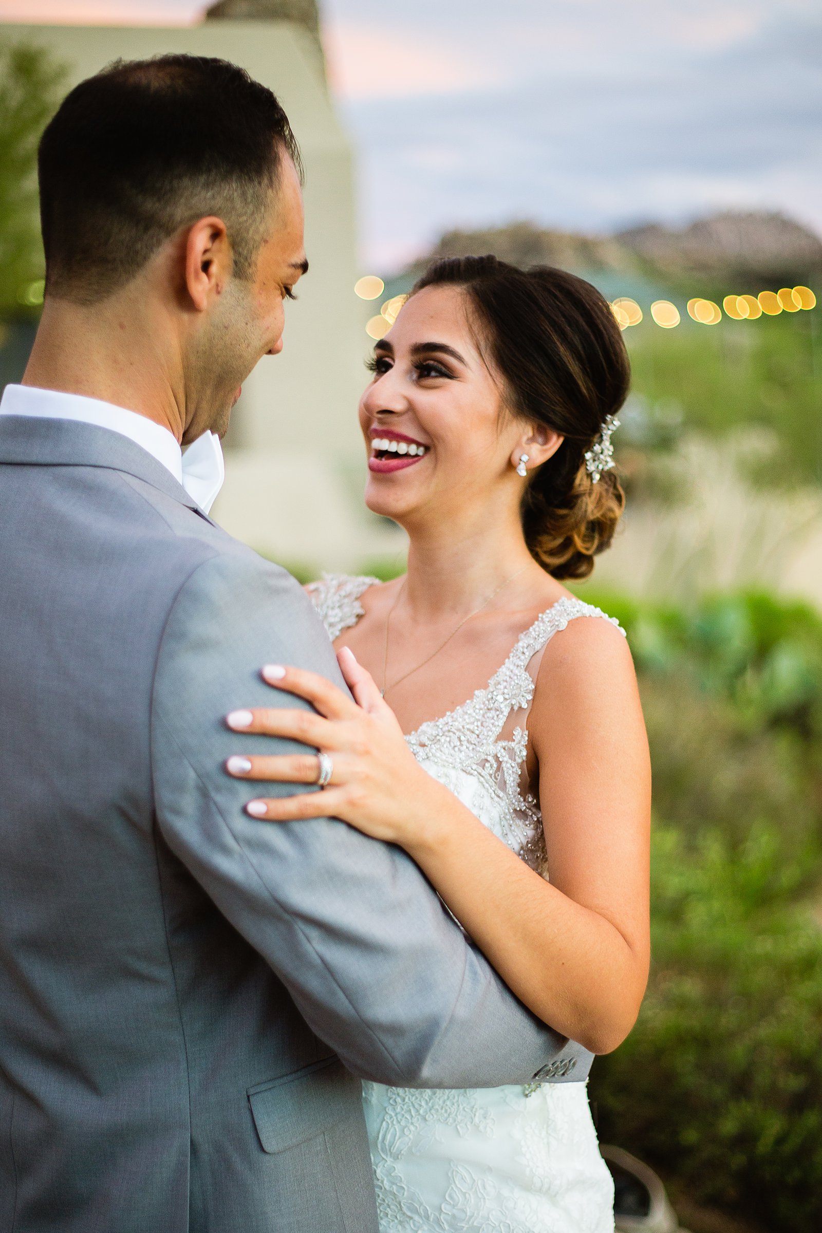 Bride and groom laughing together during their Troon North wedding by Arizona wedding photographer PMA Photography.