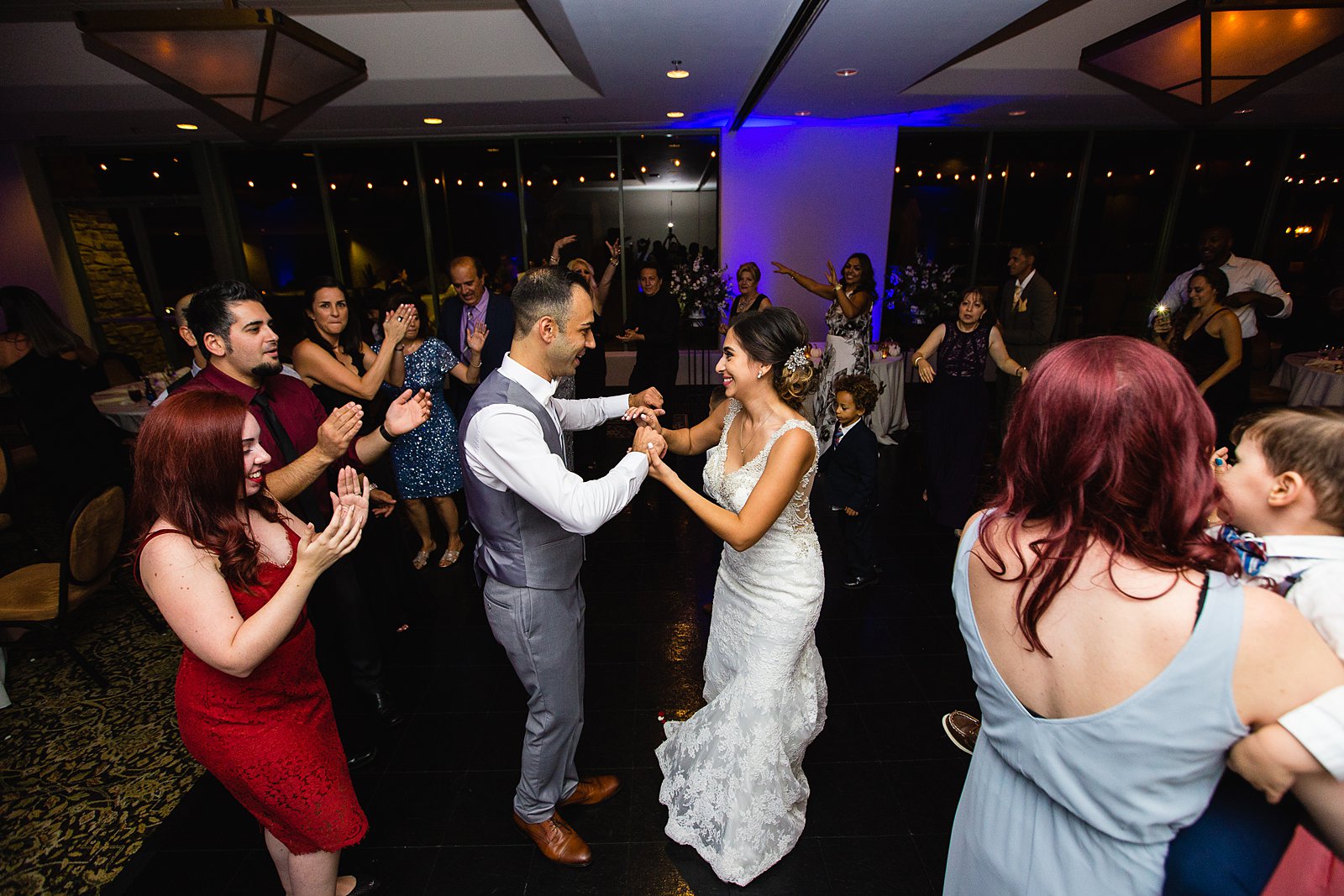 Bride and groom dancing with guests at their Troon North wedding reception by Arizona wedding photographer PMA Photography