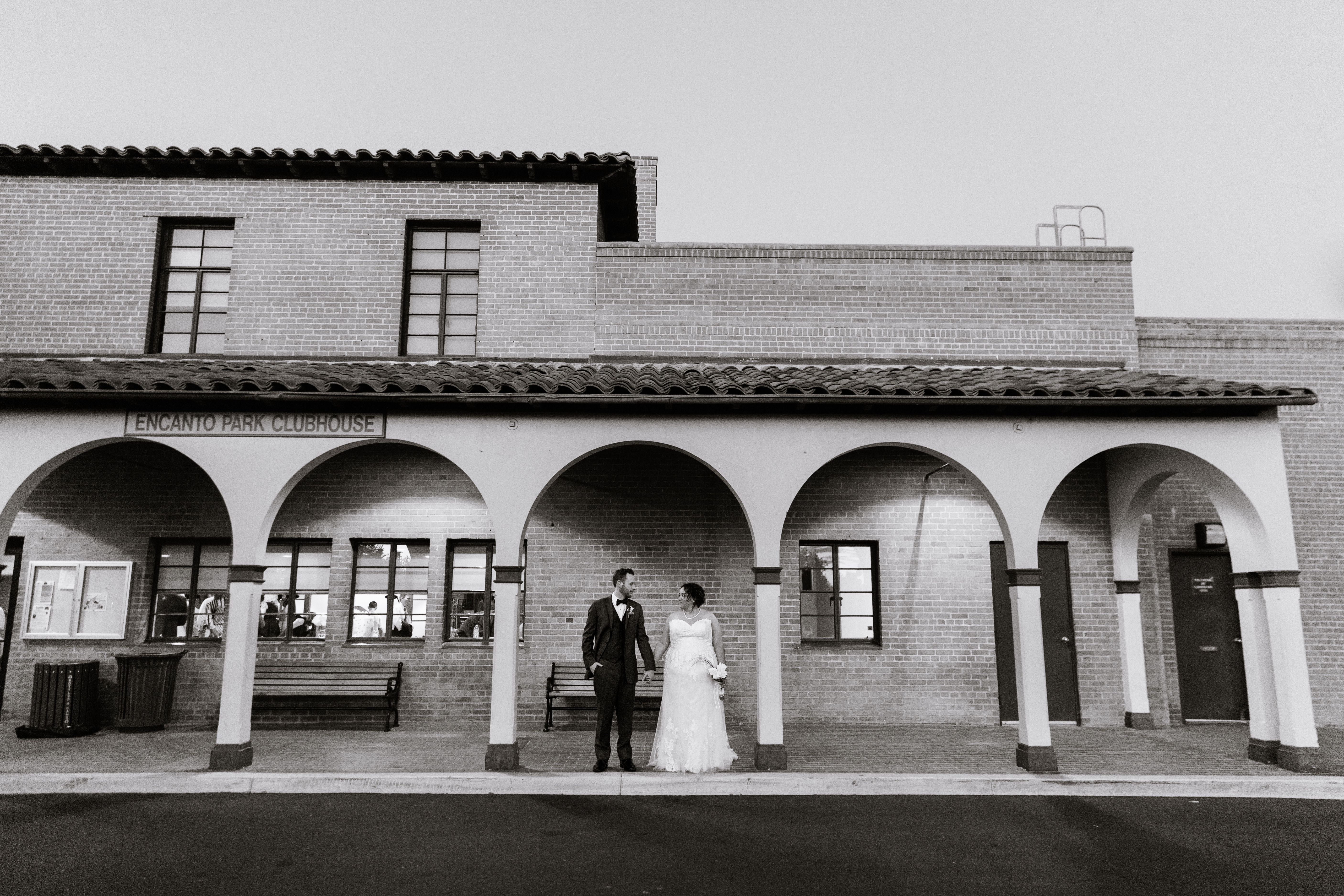 Bride and groom looking at each other outside the Encanto Park Clubhouse by Phoenix wedding photographer PMA Photography.