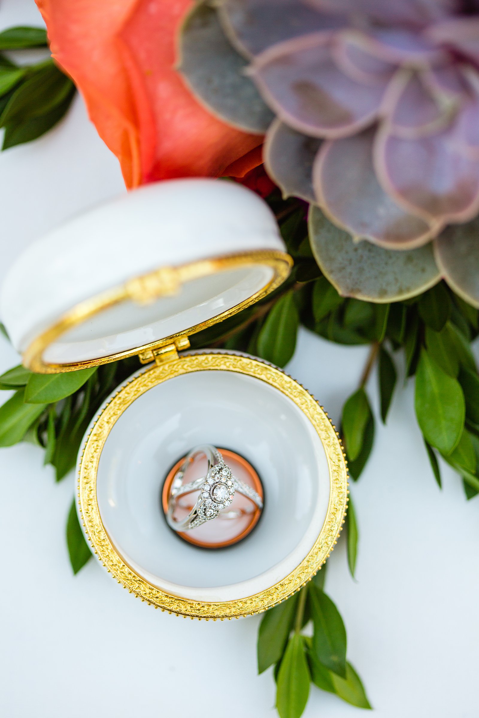 Bride and grooms wedding bands in a macaroon ring holder by PMA Photography.