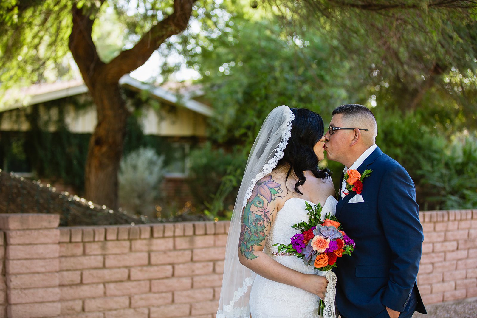 Bride and groom share a kiss during their The Farmhouse at Schnepf Farms wedding by Arizona wedding photographer PMA Photography.
