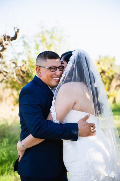 Bride and groom laughing together during their The Farmhouse at Schnepf Farms wedding by Arizona wedding photographer PMA Photography.