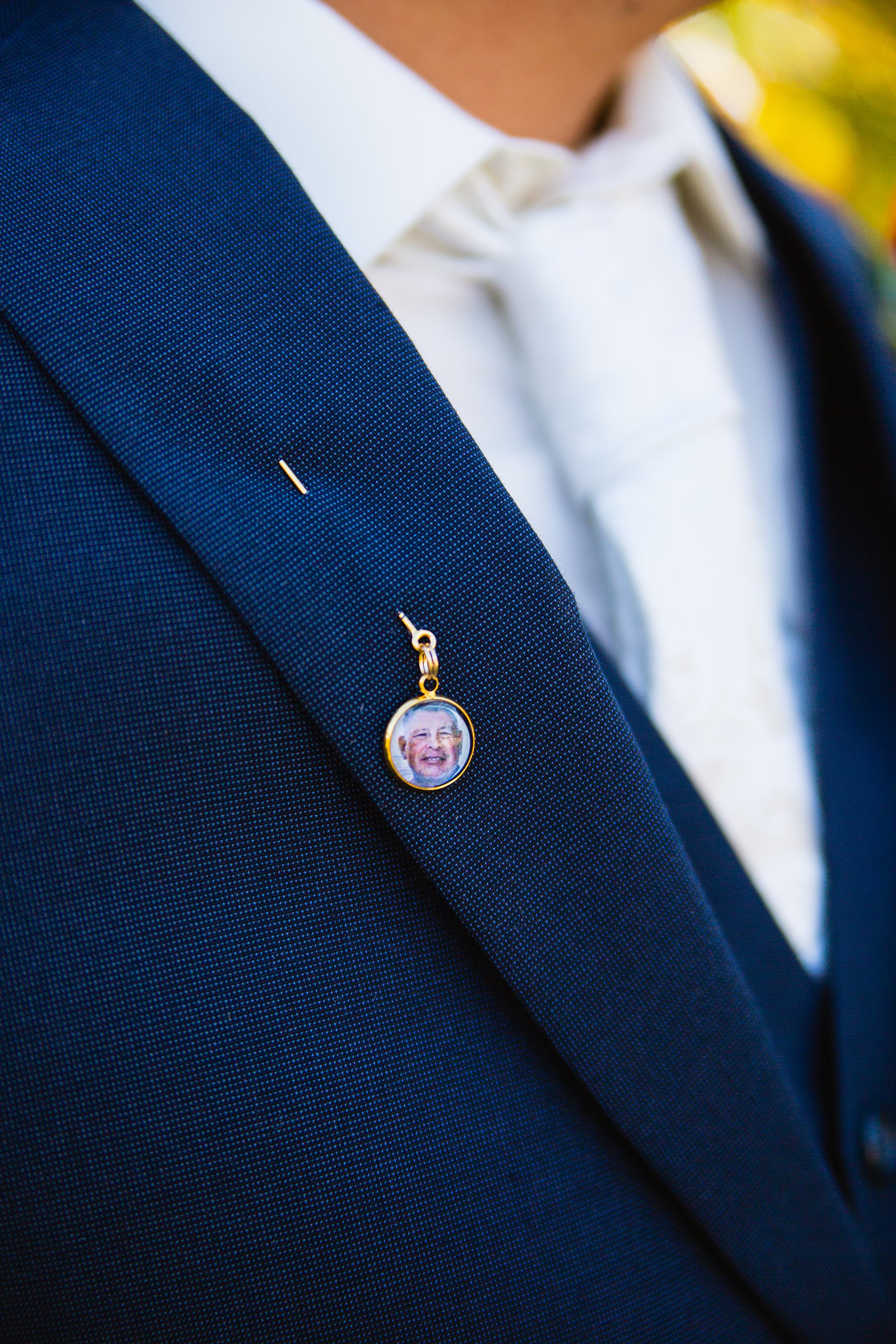 Groom wearing a pin with a picture of his father who recently past away by PMA Photography.