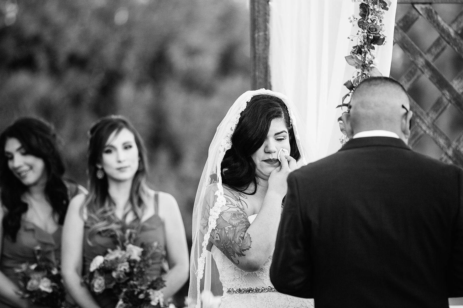 Bride crying during their wedding ceremony at The Farmhouse at Schnepf Farms by Queen Creek wedding photographer PMA Photography.