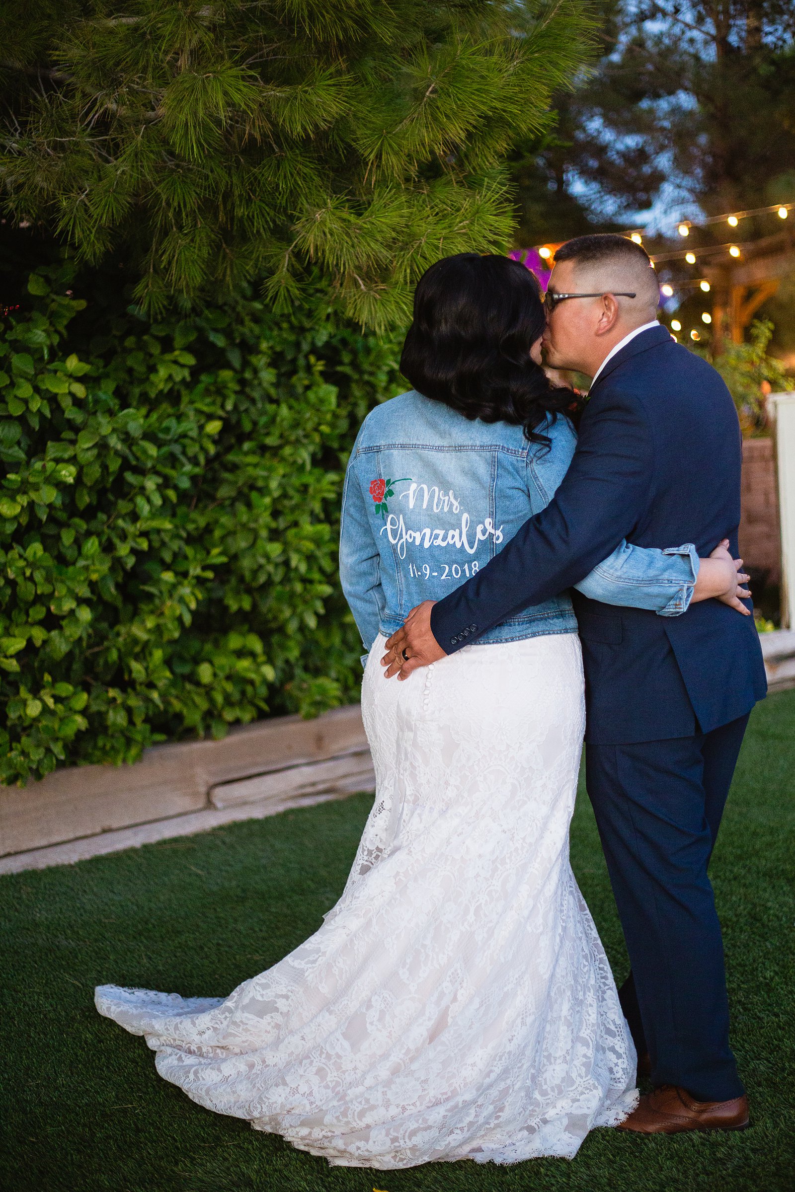 Bride and groom showing off brides custom "Mrs" denim jacket by Arizona wedding photographer PMA Photography.
