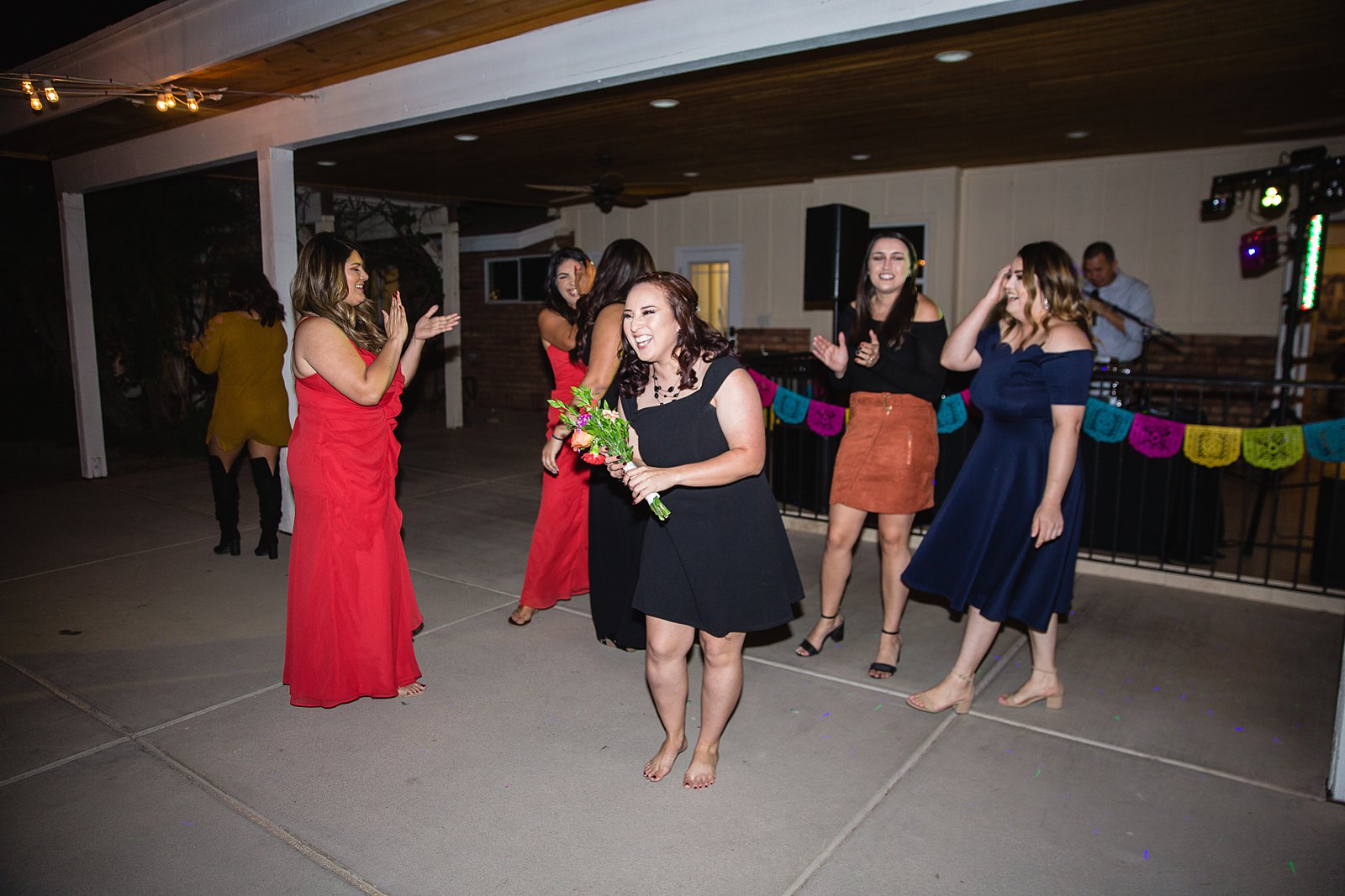 Bouquet toss at The Farmhouse at Schnepf Farms wedding reception by Queen Creek wedding photographer PMA Photography.