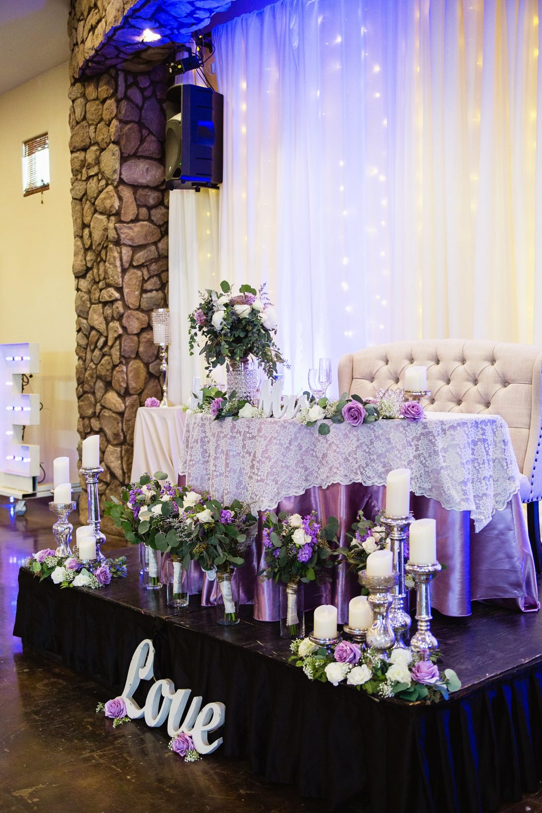 Rustic and romantic purple and white sweetheart table decorations at a Superstition Manor wedding reception by PMA Photography.