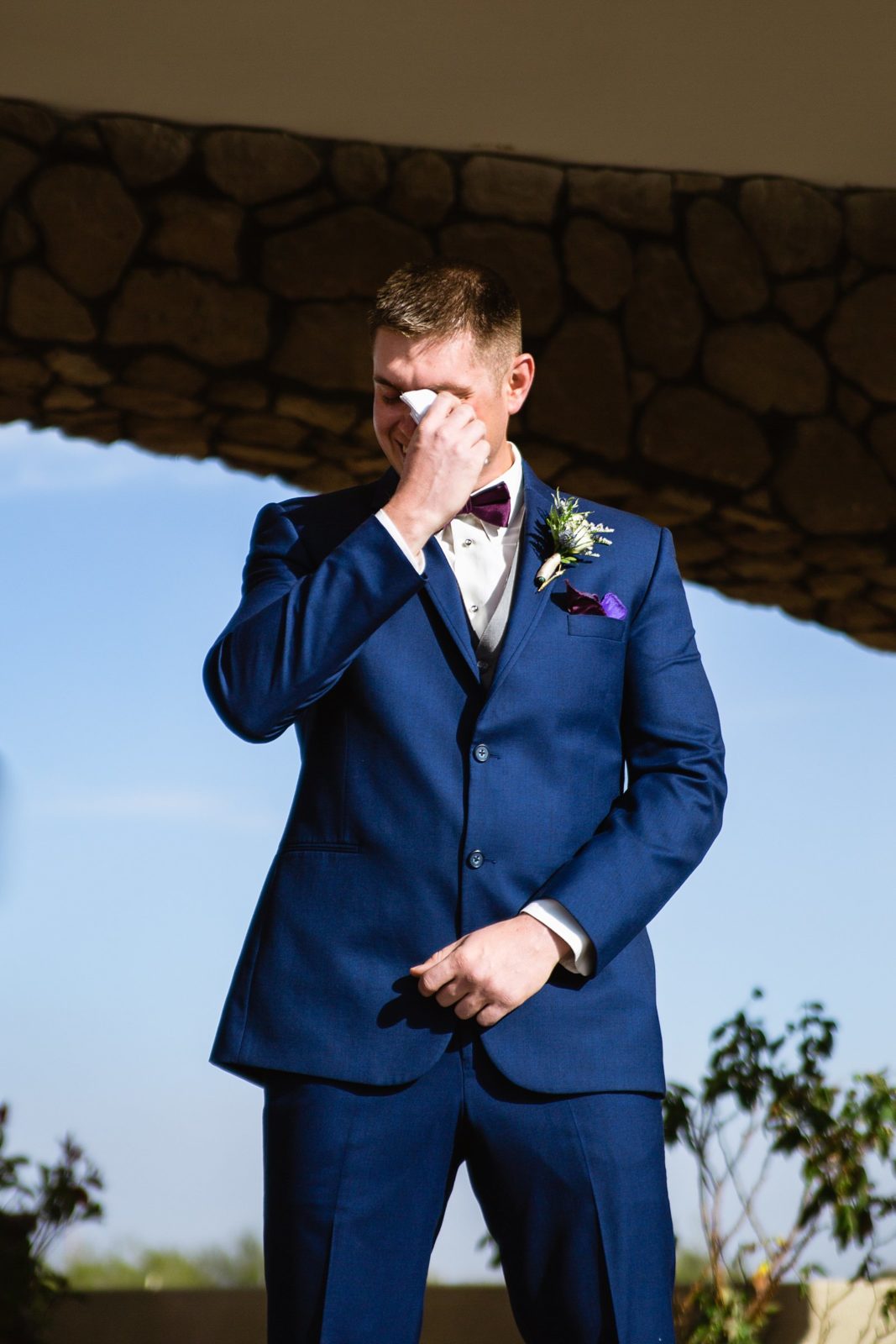 Groom wiping his tears with a hankie as the bride walks down the aisle by PMA Photography.