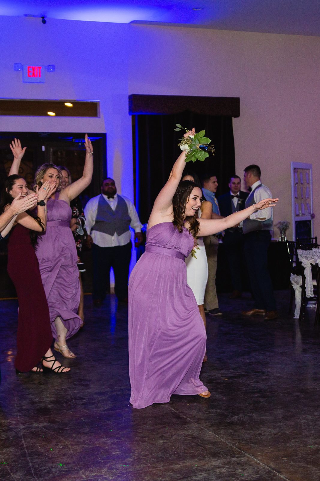Bouquet toss at Superstition Manor wedding reception by Mesa wedding photographer PMA Photography.