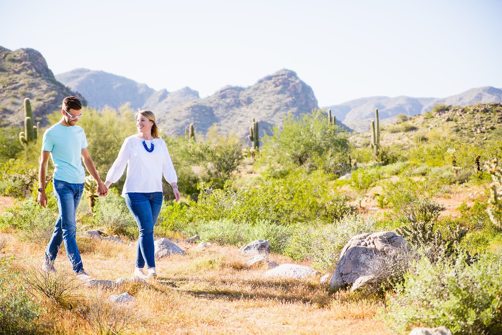 Couple walking together during their White Tanks desert engagement session by Wadell engagement photographer PMA Photography.
