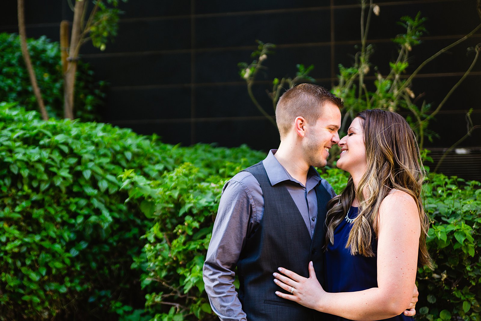 Couple laugh together during their Downtown Phoenix bar engagement session by Phoenix engagement photographer PMA Photography.