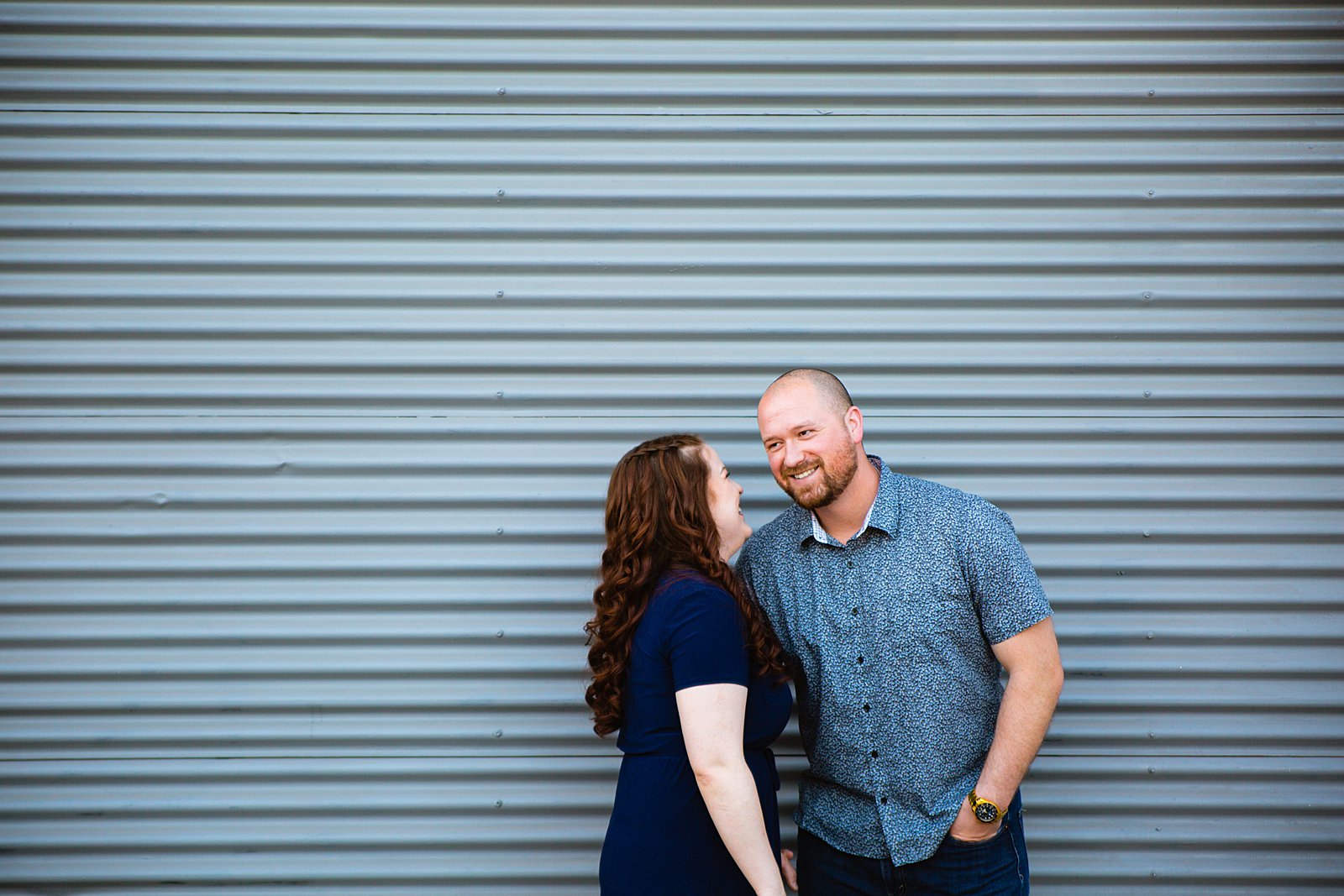 Couple laugh together during their Phoenix engagement session by Arizona engagement photographer PMA Photography.