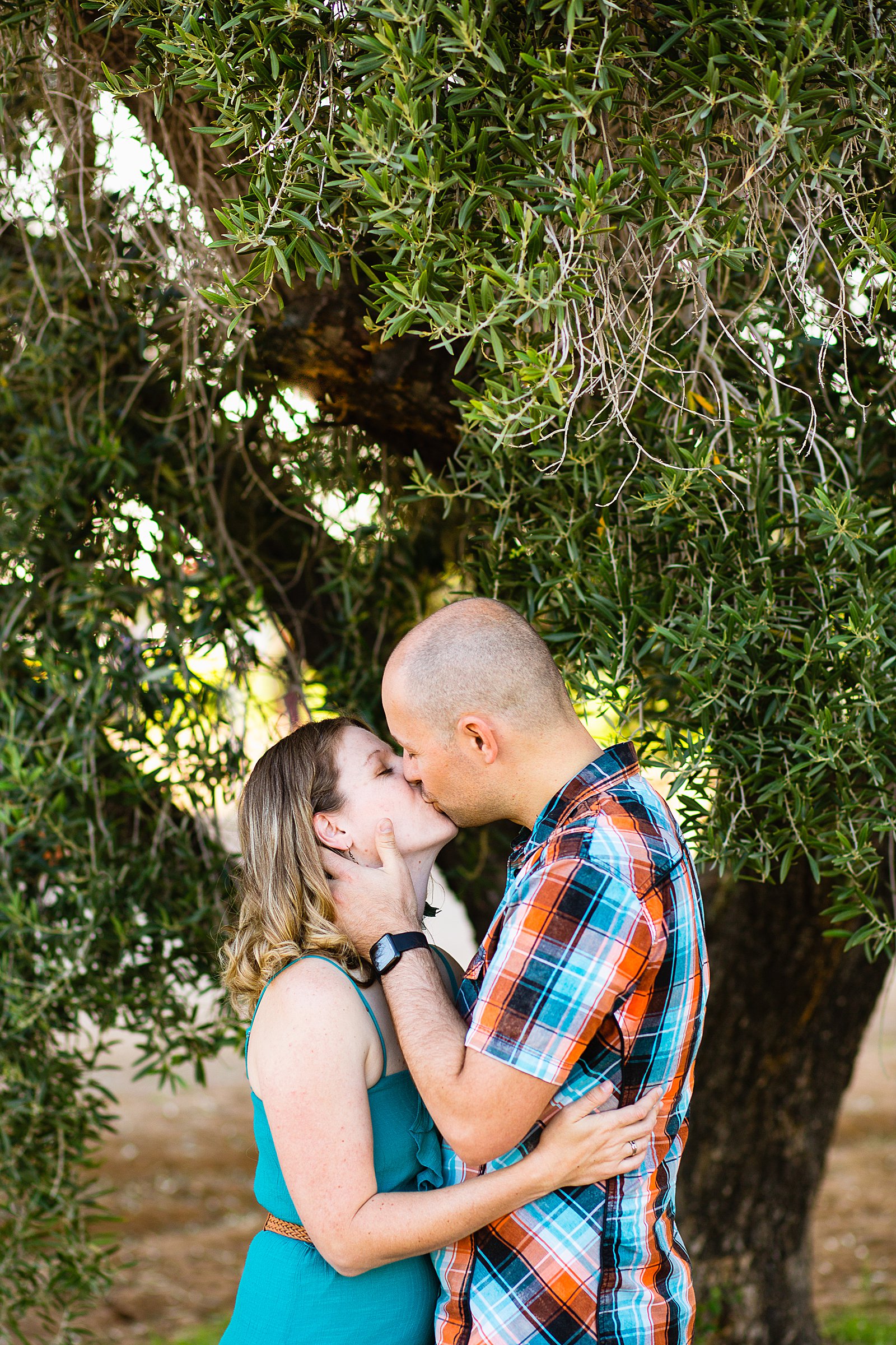 Couple share a kiss during their Sahuaro Ranch engagement session by Phoenix wedding photographer PMA Photography.