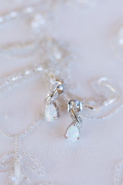 Brides's wedding day details of opal and diamond earrings by PMA Photography.
