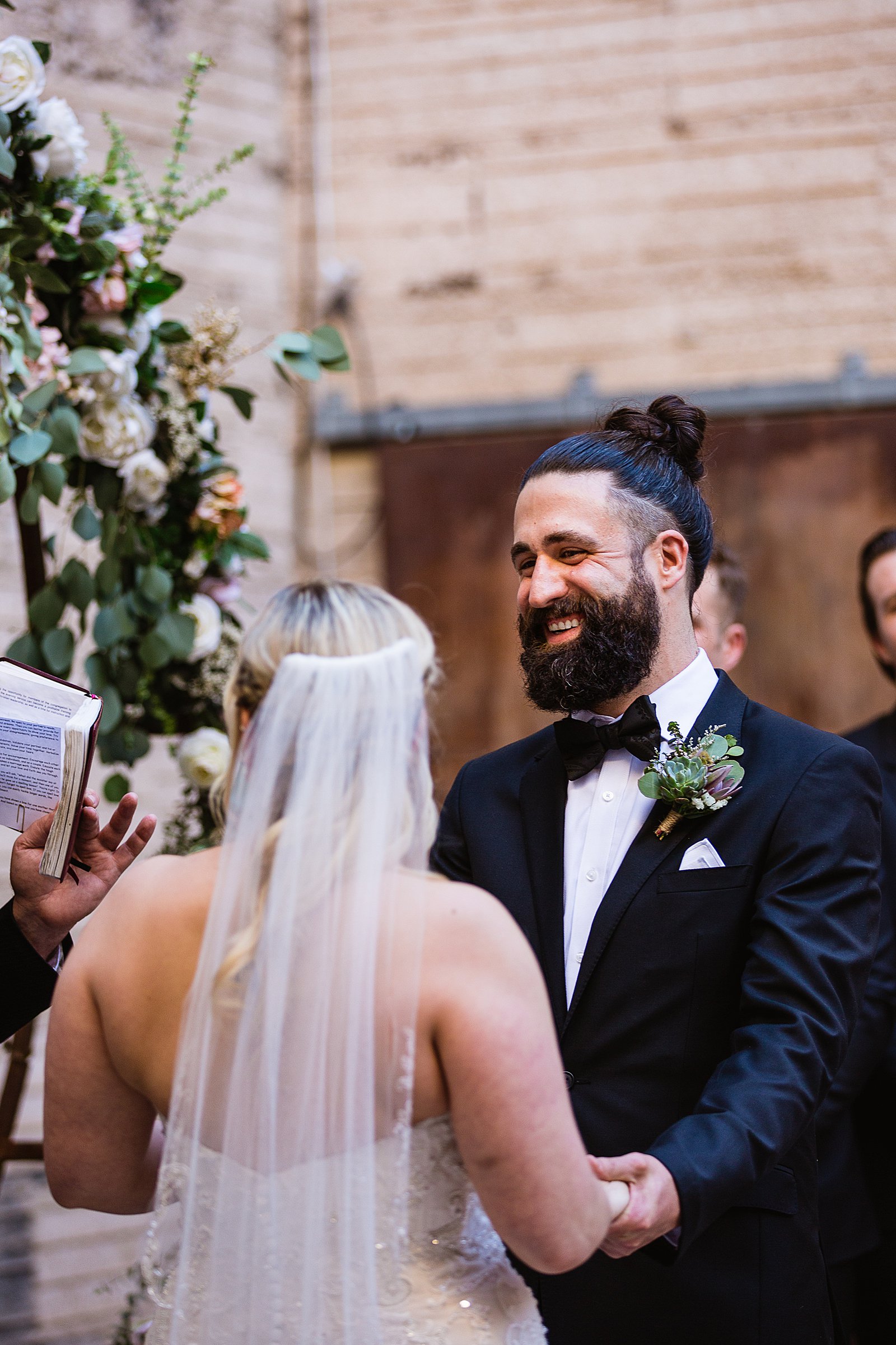 Groom looking at his bride during their wedding ceremony at The Ice House by Phoenix wedding photographer PMA Photography.
