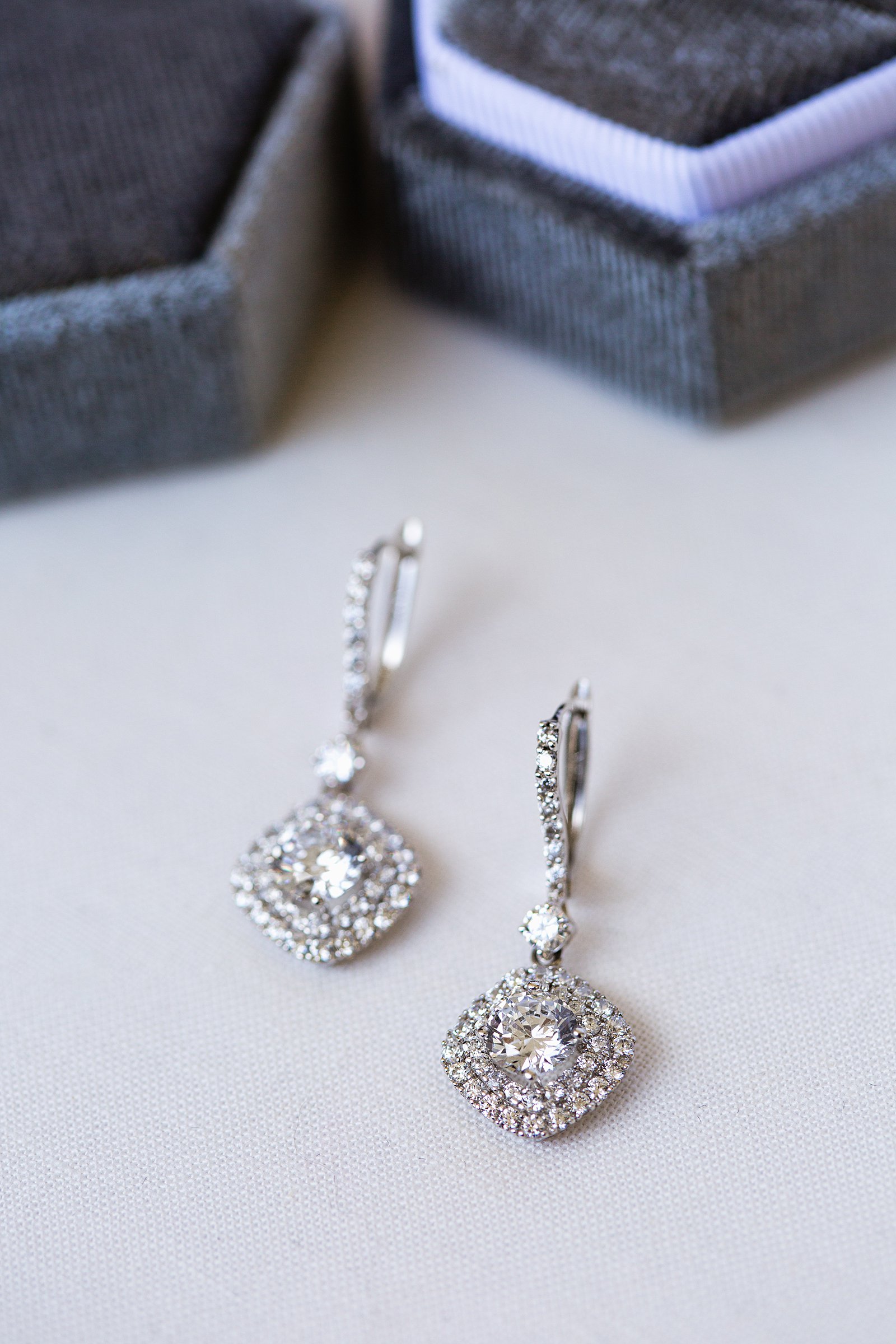 Brides's wedding day details of drop earrings by PMA Photography.
