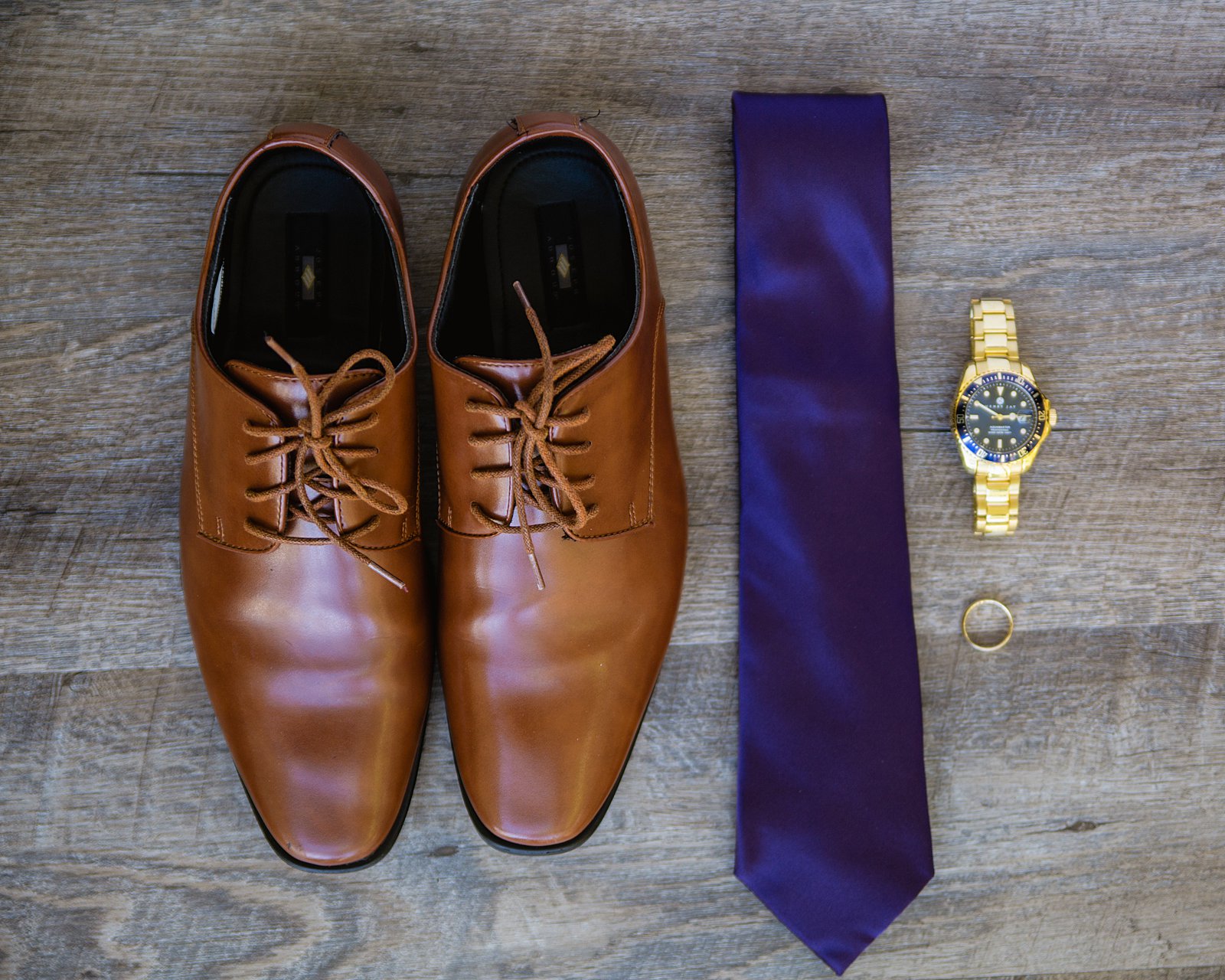 Groom's wedding day details of gold wedding ring and watch and purple tie by PMA Photography.