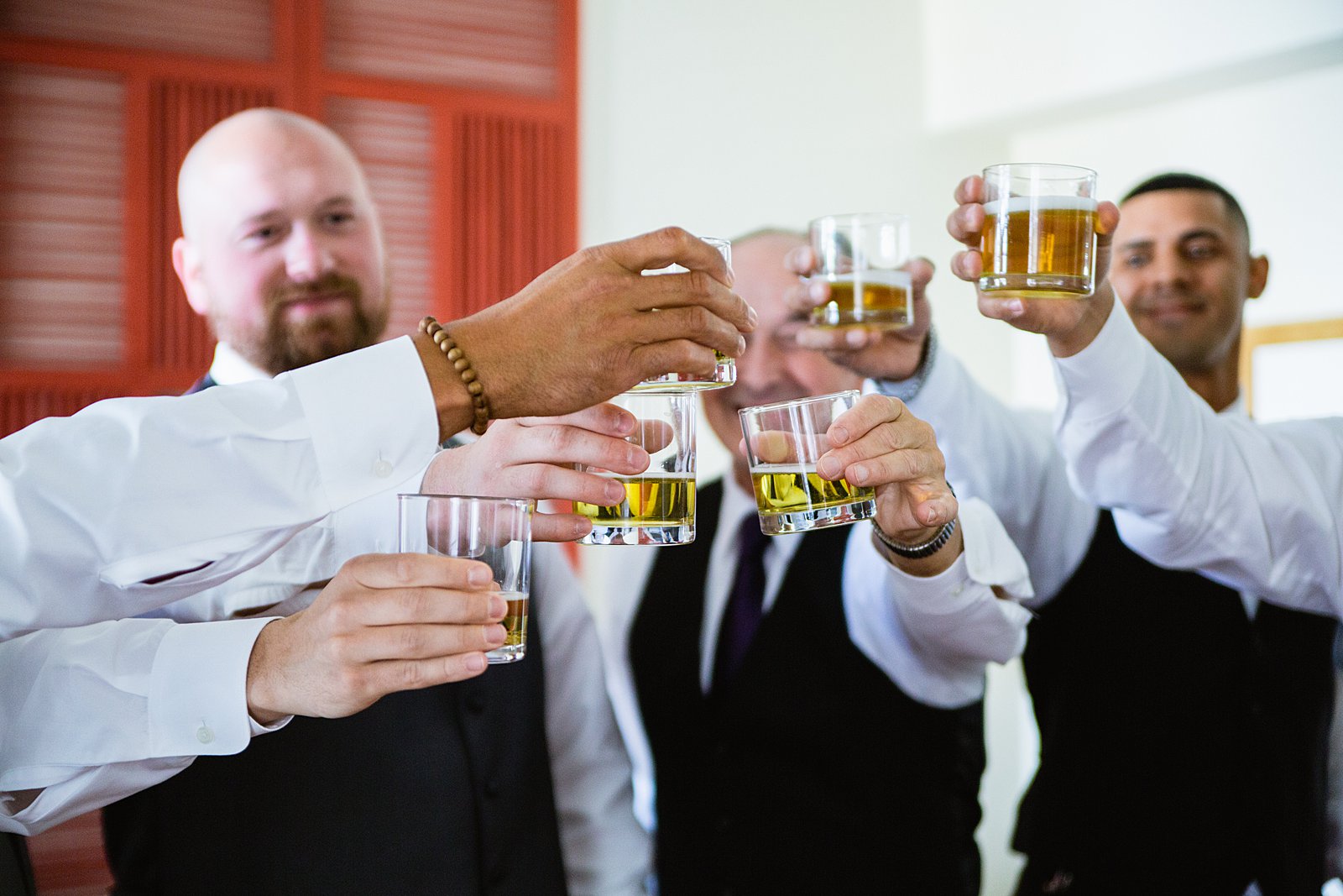 Groom toasting with guests while getting ready for his wedding by Phoenix wedding photographers PMA Photography.