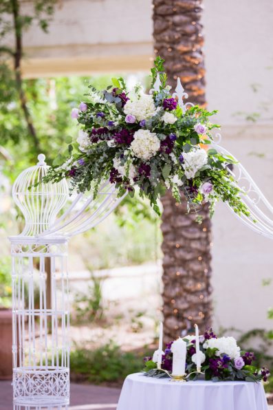 Purple and white floral wedding arch by PMA Photography.